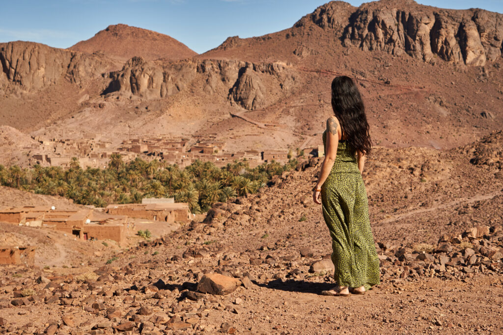 woman-between-desert-near-mountains-morocco-man-with-backpack-sitting-on-desert-dune-morocco-experts-travel-tourism